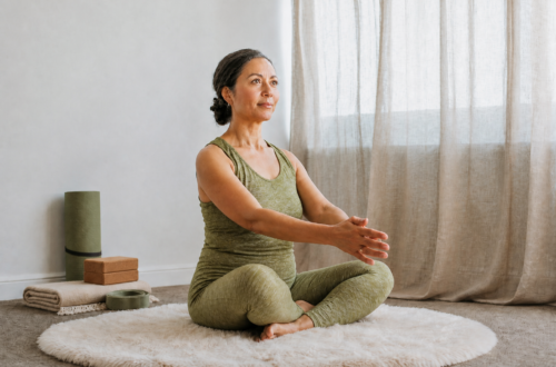 vrouw 50+ in groen yoga kleding en yoga attributen