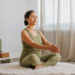 vrouw 50+ in groen yoga kleding en yoga attributen